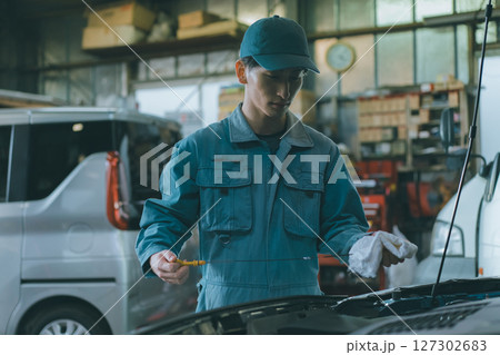 エンジンオイルを確認する自動車整備士 エンジンオイルを確認する自動車整備士 127302683
