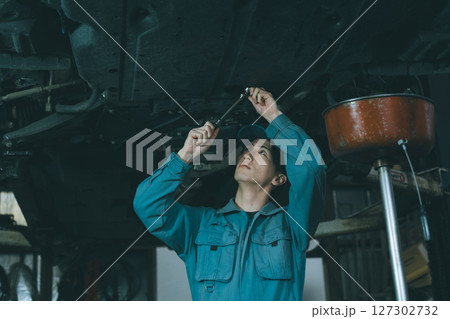 エンジンオイル交換をする自動車整備士 127302732