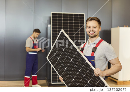 Portrait Of Happy Technician Holding Solar Panel In Store Portrait Of Happy Technician Holding Solar Panel In Store 127302973