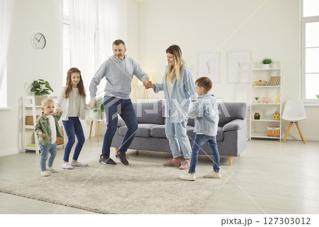 Happy big family fun dance, overjoyed married couple dancing in new modern living room 127303012