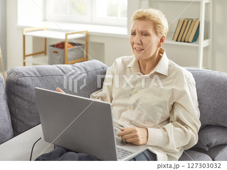 Adult mature woman in difficult problem with work, freelancer working on computer at home 127303032