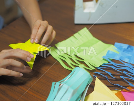 折り紙で七夕飾りを作る子供の手 127303037