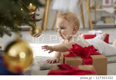 Baby Crawling Near Christmas Tree With Gifts At Home Baby Crawling Near Christmas Tree With Gifts At Home 127303102