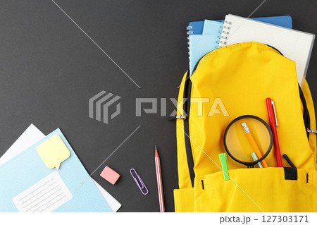School supplies in a yellow backpack. 127303171