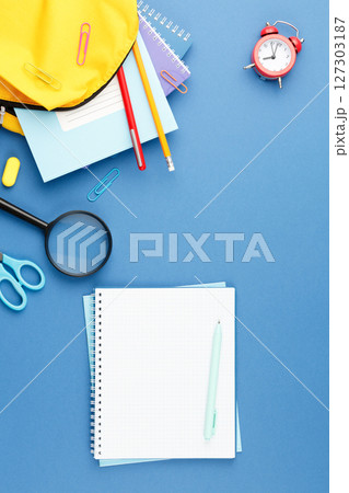School notepad with study supplies on blue desk. School notepad with study supplies on blue desk. 127303187