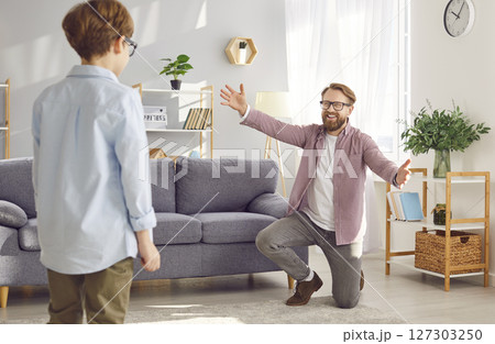 Happy young father playing with his little child boy wearing eyeglasses indoors. 127303250