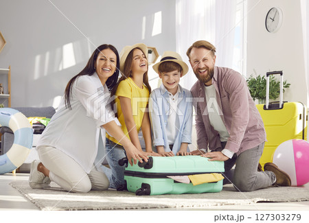 Smiling Family Packs suitcase for a Summer Vacation 127303279