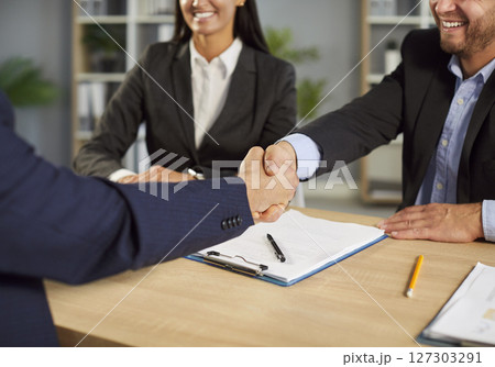 Close-Up Of Businesspeople Shaking Hands During Office Meeting For Partnership 127303291