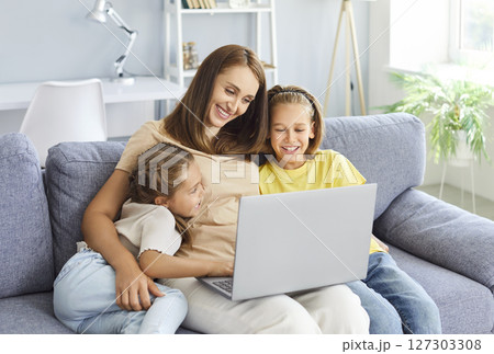 Happy family time, smiling kids, happy mom enjoying leisure at home together, using laptop 127303308