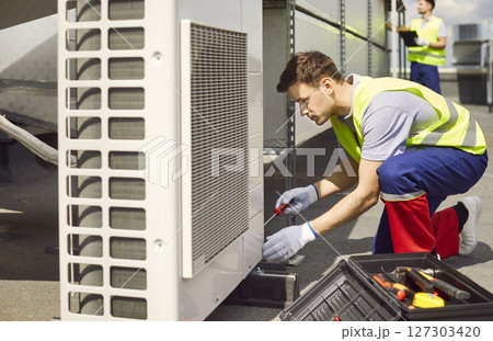 Electrician Servicing Or Repairing Hvac Or Air Conditioning System On Roof 127303420