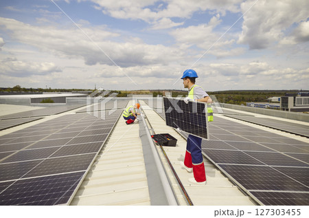 Electricians Installing And Maintaining Solar Panels On Roof 127303455