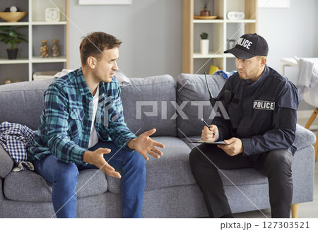 Policeman interrogating at home, officer police man in uniform, witness interview, interviewing  127303521