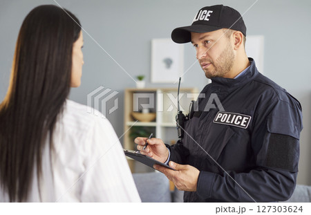 Policeman asking, interrogating woman, officer police man in uniform, interviewing criminal Policeman asking, interrogating woman, officer police man in uniform, interviewing criminal 127303624