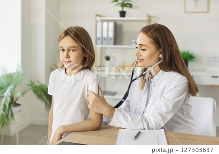 Pediatrician checking lung, heart of kid patient in clinic, female doctor, nurse holding stethoscope Pediatrician checking lung, heart of kid patient in clinic, female doctor, nurse holding stethoscope 127303637