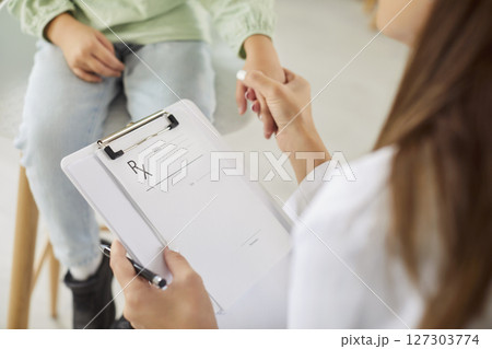 Friendly doctor holding hands with preschool girl during checkup with care and support in clinic. Friendly doctor holding hands with preschool girl during checkup with care and support in clinic. 127303774
