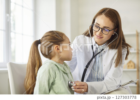 Young woman pediatrician with stethoscope examining little child patient at clinic Young woman pediatrician with stethoscope examining little child patient at clinic 127303778