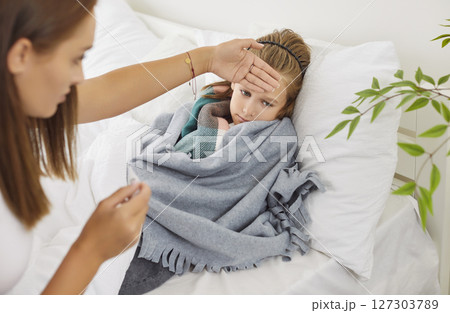 Mother Checking Her Sick Son's Temperature At Home During A Cold Or Flu 127303789
