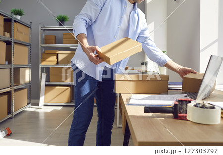Businessman Managing Inventory At Online Store Warehouse Businessman Managing Inventory At Online Store Warehouse 127303797
