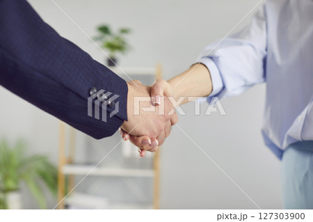 Handshake Between Two Business People In Office 127303900