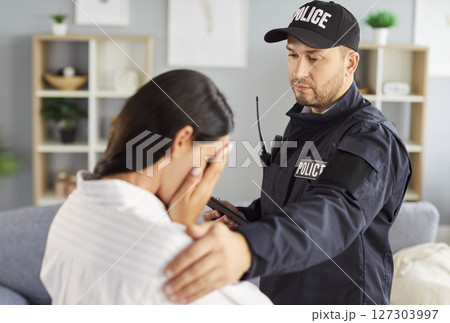 Portrait of a young woman crime victim standing with policeman supporting her. Portrait of a young woman crime victim standing with policeman supporting her. 127303997