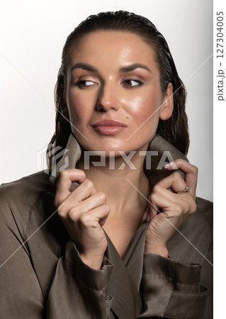 Beautiful woman with trench coat and wet hair studio portrait Beautiful woman with trench coat and wet hair studio portrait 127304005