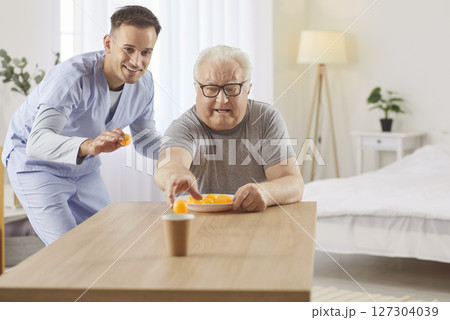 Happy Elderly Man Playing A Game With Caregiver At Nursing Home For Relaxation Happy Elderly Man Playing A Game With Caregiver At Nursing Home For Relaxation 127304039