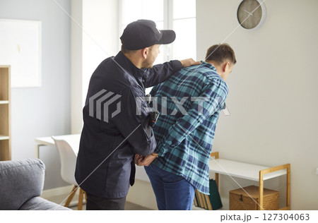 Police Officer Arresting Male Suspect With Handcuffs 127304063