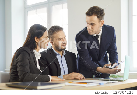 Young couple sitting with a business broker or insurance agent showing project on a laptop screen. Young couple sitting with a business broker or insurance agent showing project on a laptop screen. 127304129