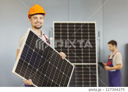 Smiling Worker Holding Solar Panel In Store 127304275
