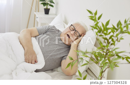 Senior Man Sleeping In Bed Early In The Morning In His Bedroom At Home Senior Man Sleeping In Bed Early In The Morning In His Bedroom At Home 127304328