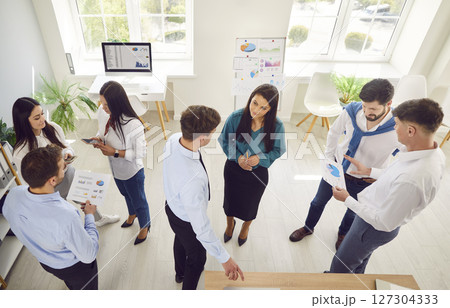 Group of young confident business people men and women talking in office during a meeting. Group of young confident business people men and women talking in office during a meeting. 127304333