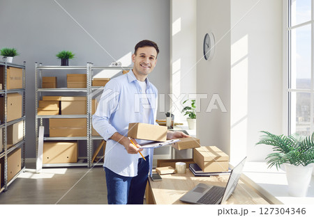 Man working in warehouse checking stock and inventory sitting standing workplace in storeroom. 127304346
