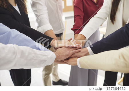 Close up top view photo of business people putting their arms together in stack. Close up top view photo of business people putting their arms together in stack. 127304482