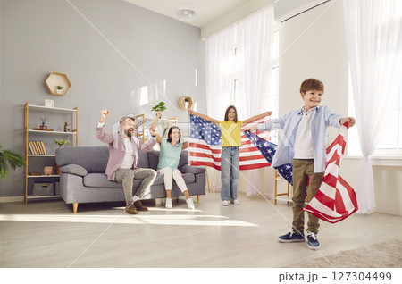 Family with two kids sitting at home with flag of united states celebrating Independence Day. 127304499
