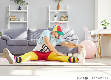 Funny Man Stretching During Home Workout And Sitting On Floor 127304535