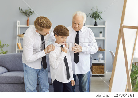 Happy multi generation family of men wearing white shirts and ties preparing for special occasion. Happy multi generation family of men wearing white shirts and ties preparing for special occasion. 127304561