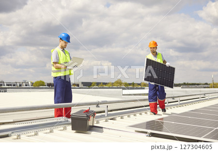 Electricians Workers Installing Solar Panels On Roof For Renewable Energy 127304605