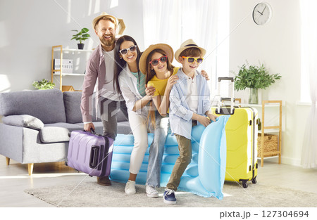 Happy young family having fun ready for summer holiday trip standing at home. 127304694
