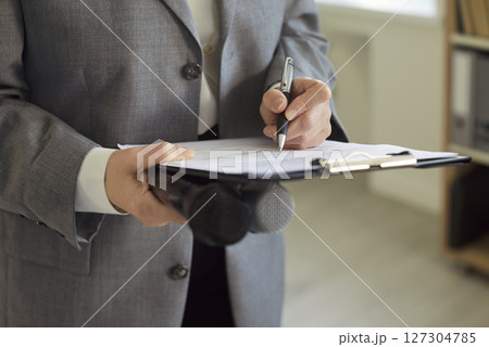 Newspaper journalist or news reporter with microphones and clipboard taking notes on paper 127304785