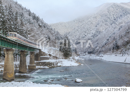雪に覆われた第13宮川橋梁を雪煙を上げて駆け抜ける高山本線 127304799