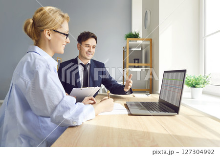 Colleagues Working With Graphs And Laptop In Office Meeting 127304992