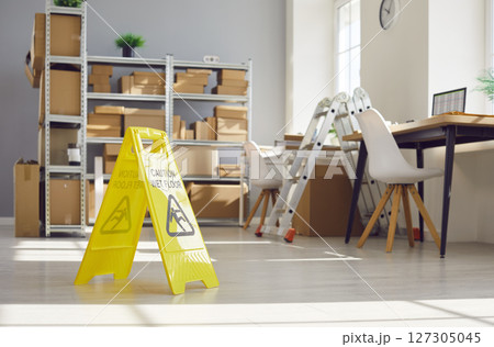 Yellow Sign Caution, Wet Floor In Empty Warehouse 127305045