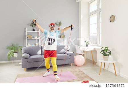 Funny Man Working Out At Home With Fitness Bands For Stretching Exercise Funny Man Working Out At Home With Fitness Bands For Stretching Exercise 127305271