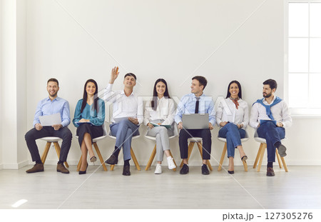 Business Colleagues In Office Meeting, Raising Hands To Ask Questions 127305276