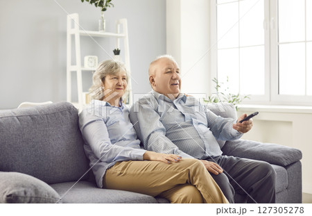 Happy Elderly Family Couple Watching Tv Together On Sofa At Home 127305278