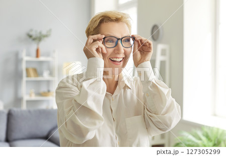 Happy older woman in elegant glasses looking with beautiful toothy smile, laughing enjoys eyeglasses Happy older woman in elegant glasses looking with beautiful toothy smile, laughing enjoys eyeglasses 127305299