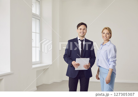 Portrait Of Happy Realtor And Customer In New Home Or Office Portrait Of Happy Realtor And Customer In New Home Or Office 127305307