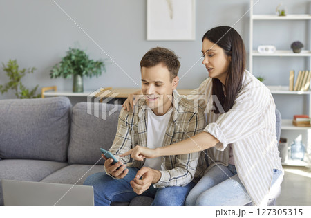Family Couple Enjoying Online Leisure At Home With A Smartphone Family Couple Enjoying Online Leisure At Home With A Smartphone 127305315