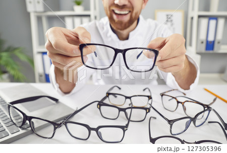 Close Up Of Positive Ophthalmologist Showing Eyeglasses In Office 127305396