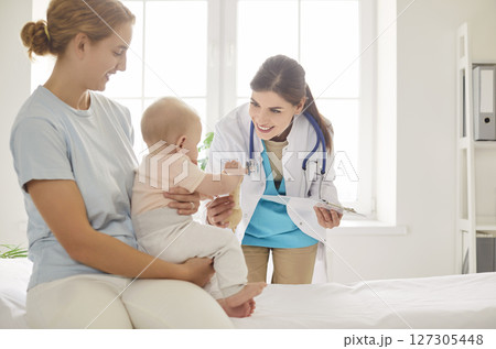 Mother And Baby Visiting Pediatrician At Clinic For Healthcare Appointment 127305448